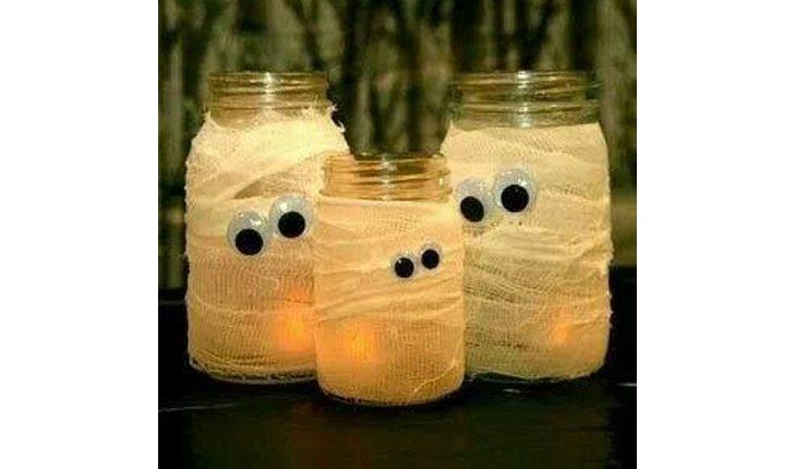 Na foto há uma ideia de decoração de Halloween com potes de vidro decorados de múmias