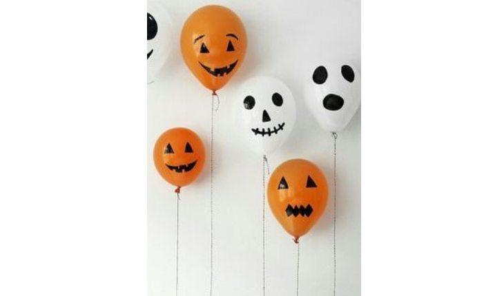 Na foto há uma ideia de decoração de Halloween com balões com caretas