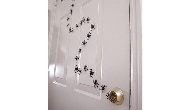 Na foto há uma ideia de decoração de Halloween com pequenas aranhas.