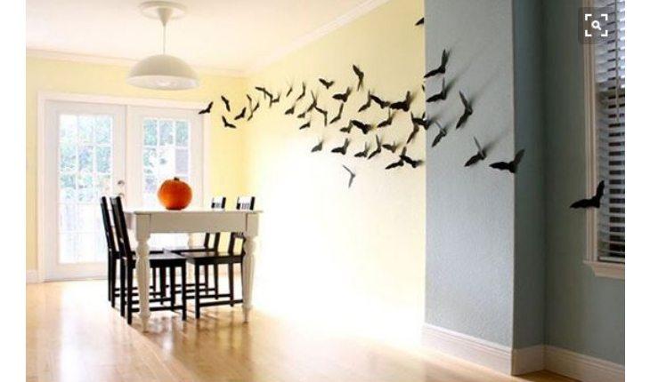Na foto há uma ideia de decoração de Halloween com morcegos de papel colados na parede.