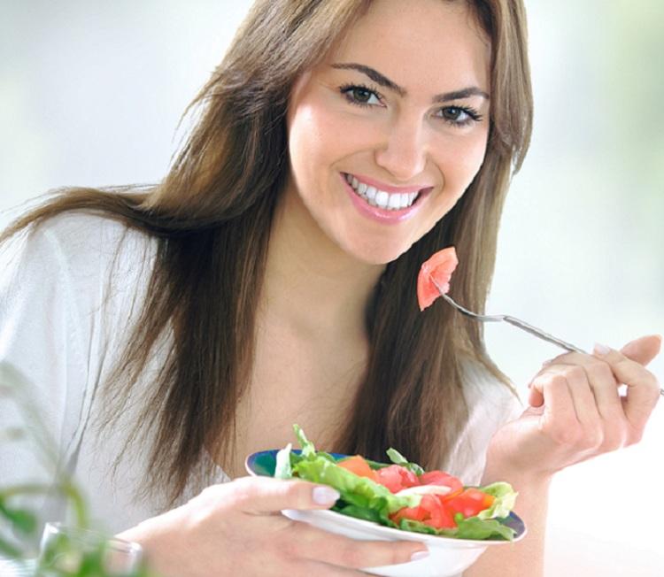 mulher comendo uma salada 