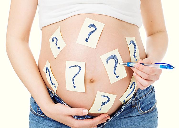 mulher grávida com postits com ponto de interrogação colados na barriga