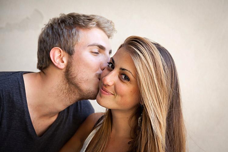 Homem beijando o rosto da mulher para conquistá-la