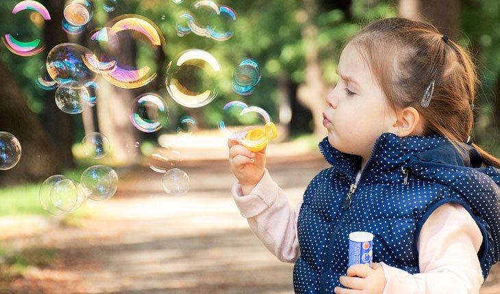 Dia das Crianças. Na foto, menininha fazendo bolhas de sabão