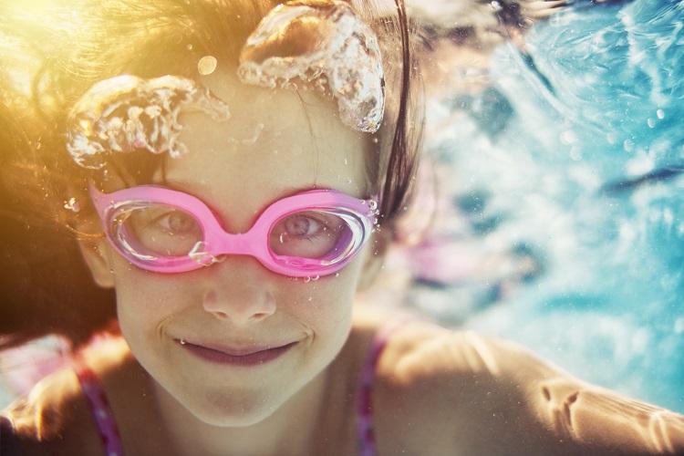 menina com óculos rosa fazendo natação