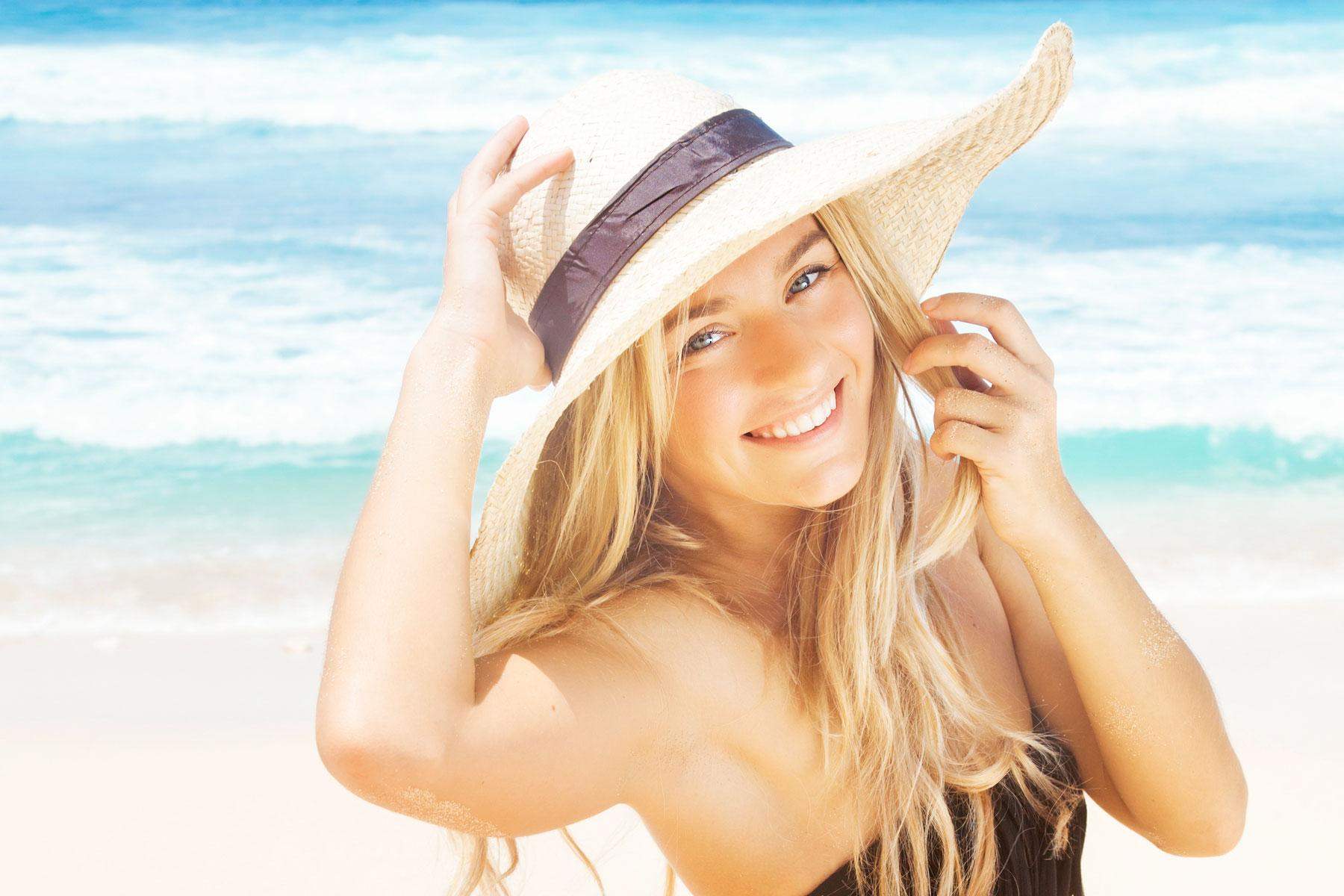 Mulher sorrindo com chapéu e o lindo cabelo loiro no verão