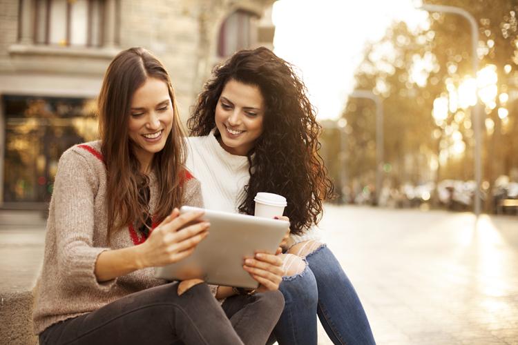 mulheres-sentadas-conversando-digitando-tablet-videochamadas-iPhone e iPad