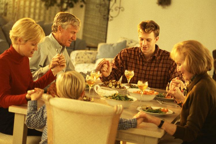 Família sentada à mesa comendo