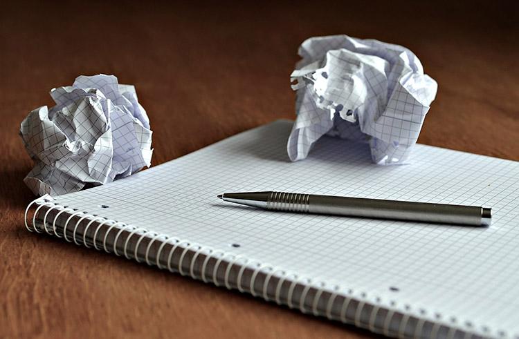 papel amassado, caneta, folha em branco