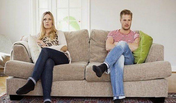 homem e mulher sentados em um sofá, um em cada ponta
