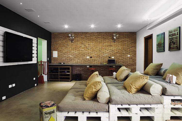 Sala de apartamento alugado decorada com arquibancada sofá feita de pallets