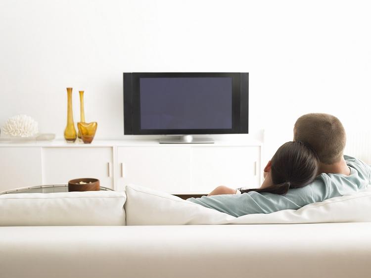 casal-sentado-sofá-assistindo-tv-recurso-espelhamento-airplay-iphone e ipad