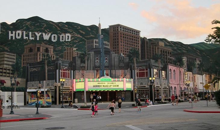 Uma das esquinas da Hollywood Boulevard, com um grande letreiro de cinema. Acima, os letreiros de Hollywood.