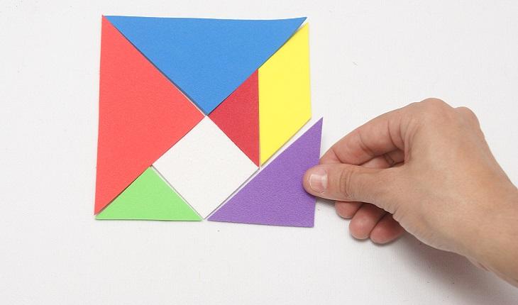 A foto mostra uma pesoa resolvendo um tangram. A atividade ajuda a desenvolver o cérebro