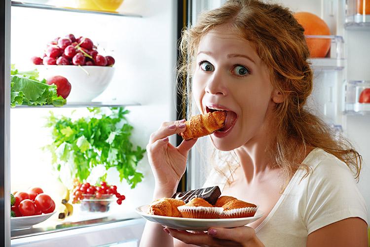 mulher-comendo-alimentos-caloricos-geladeira-aberta