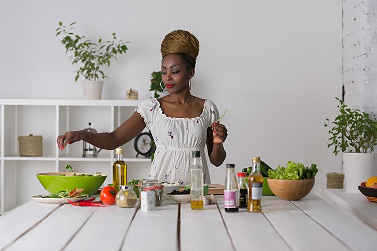 mulher-cozinha-mesa-alimentos-legumes-frascos