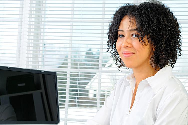 mulher negra em frente ao computador no trabalho