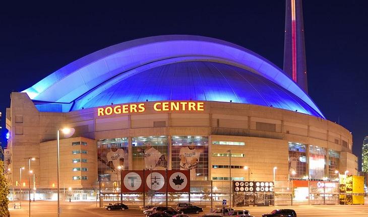 Vista de fora do Rogers Centre, com uma iluminação azul em seu teto.