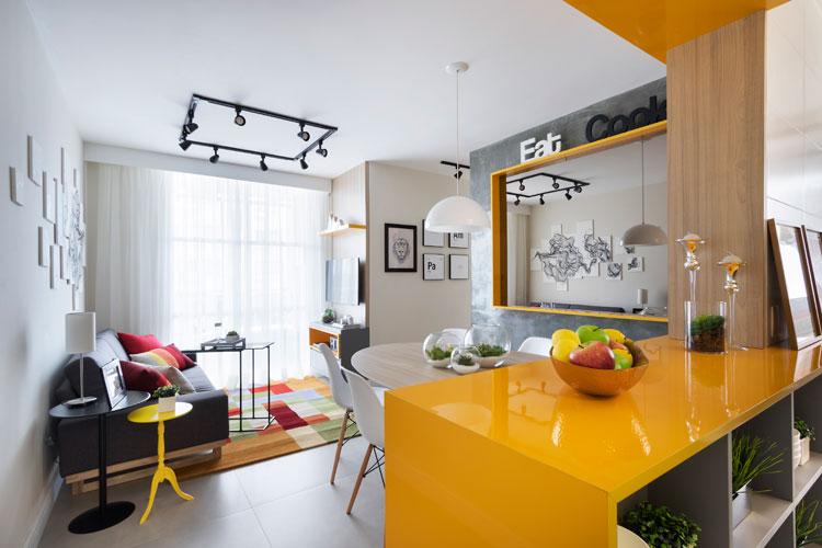 Ambiente de um apartamento pequeno decorado com tons de cinza e amarelo