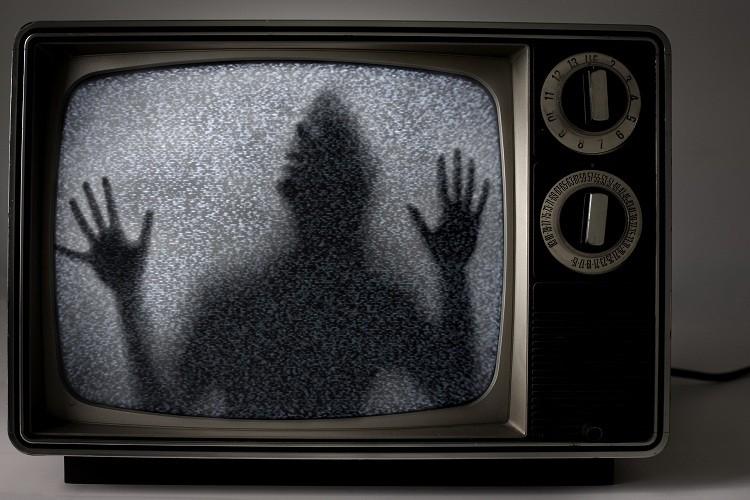 assombrações representadas por um fantasma saindo de uma tv em preto e branco