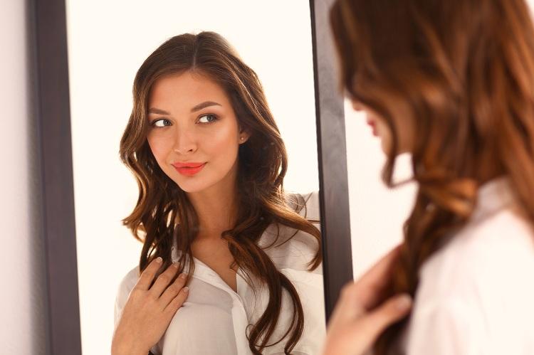 mulher se olhando refletida no espelho simbolizando ego e autoafirmação