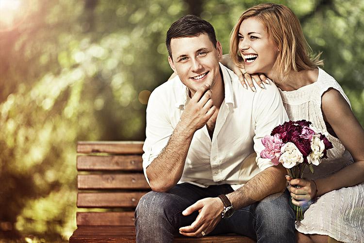 casal feliz, sorrindo, sentado em um banco