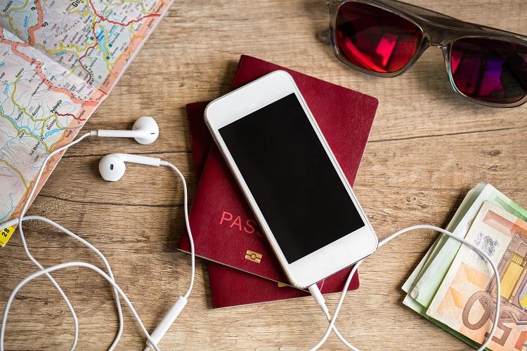 celular-em-cima-mesa-fones-de-ouvido-passaporte-mapa-de-viagem-aplicativo-facebook