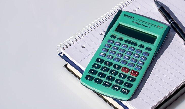 calculadora verde em cima de um caderninho