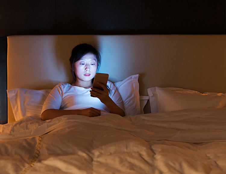 mulher usando o celular antes de dormir 