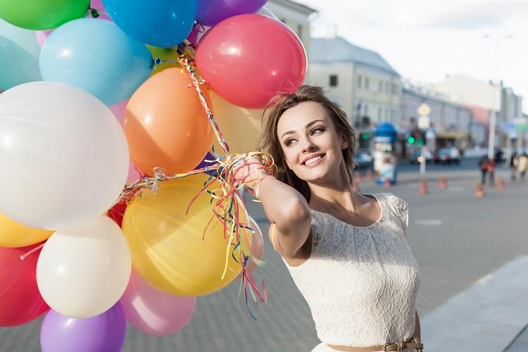 mulher feliz segurando balões