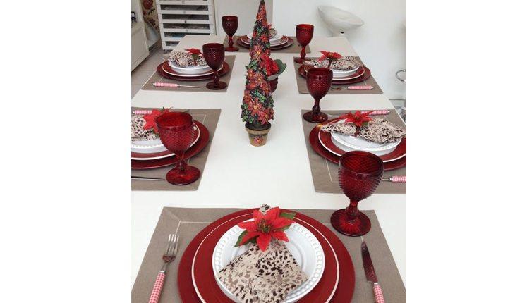 mesa de natal decorada nas cores vermelha, branca e bege com enfeites ao centro