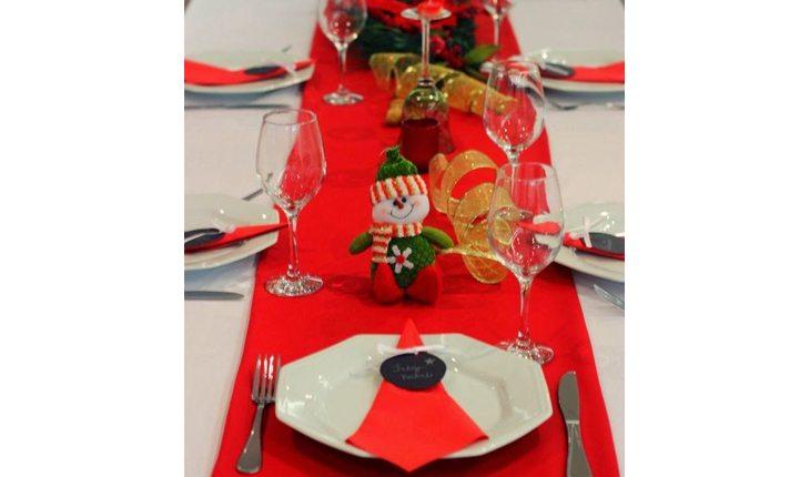 mesa de natal com caminho de mesa vermelho e outros enfeites de natal