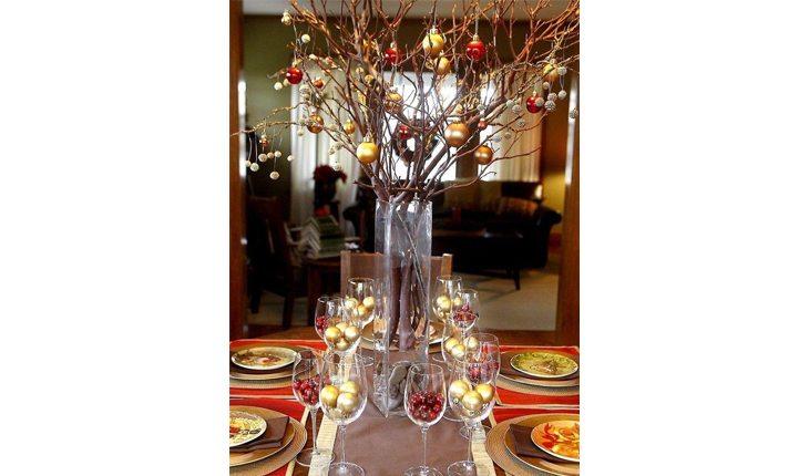 mesa decorada para o natal com taças cheias de bolinhas de natal e outros enfeites nas cores dourada, vermelha e verde