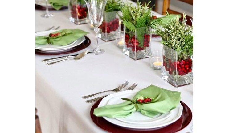 mesa decorada para o natal com toalha branca e elementos em verde-claro
