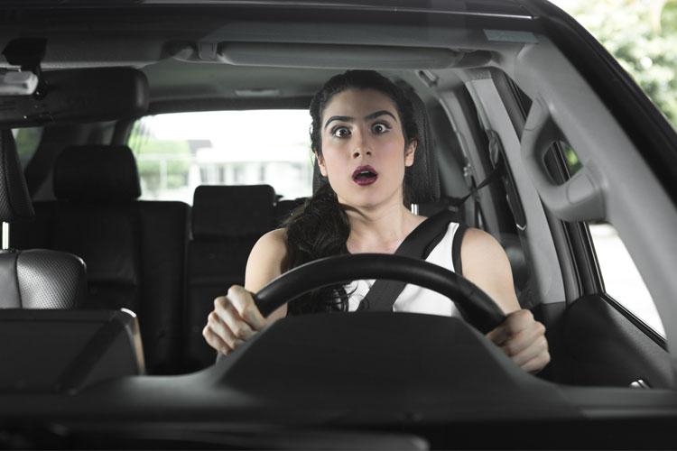 Mulher dirigindo assustada com o trânsito