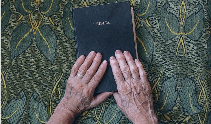 pessoa com as mãos sobre a bíblia
