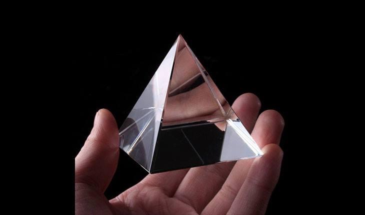 Pessoa segurando pirâmide de vidro