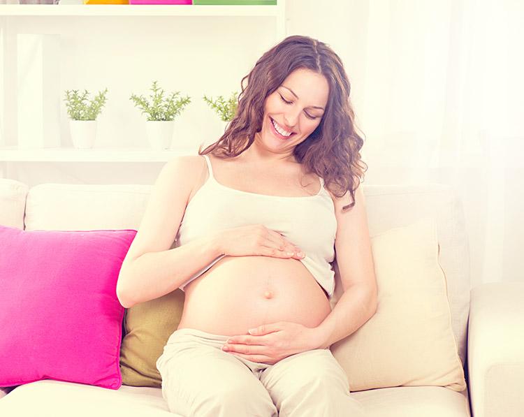 mulher sentada sofa gravidez barriga
