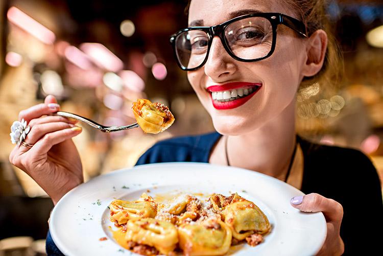 mulher sorrindo segurando um prato de comida