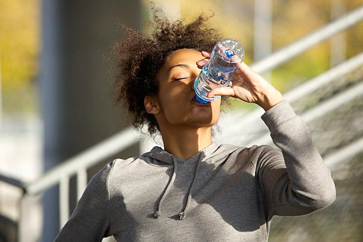 mulher magra bebendo água hidratação saúde