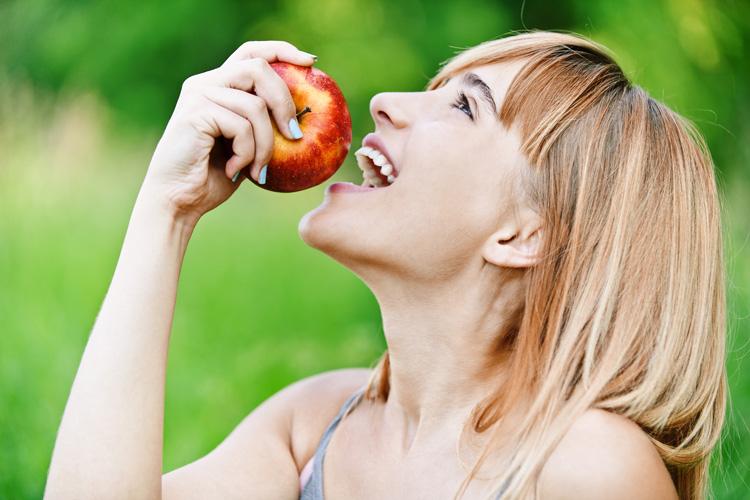 mulher comendo maçã na TPM