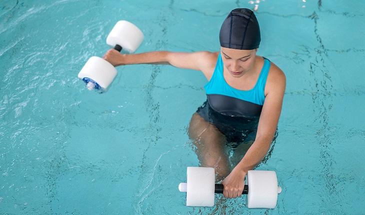 Na foto há uma mulher dentro de uma piscina fazendo hidroterapia, uma das terapias eficientes contra artrite e artrose