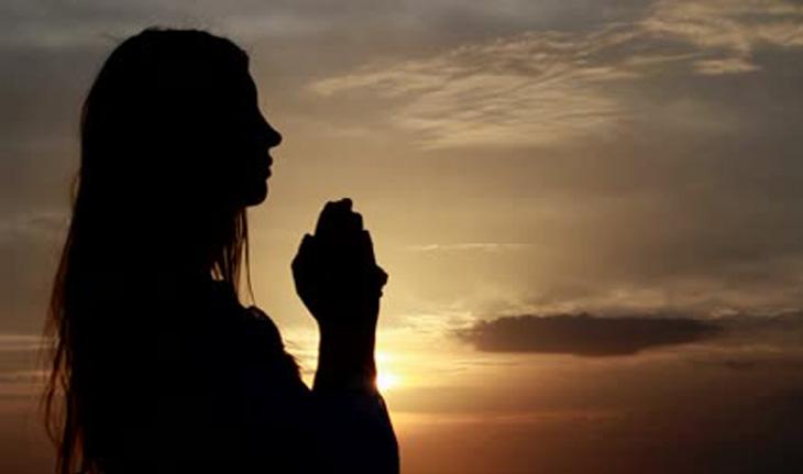 mulher rezando olhando para o céu