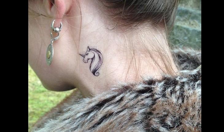 Tatuagem de um unicórnio minimalista feita no pescoço