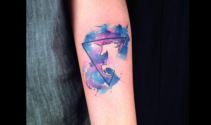 Tatuagem de um unicórnio, dentro de um triângulo em aquarela
