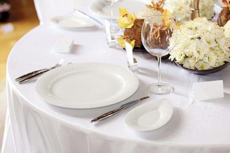 Mesa com pratos brancos e flores