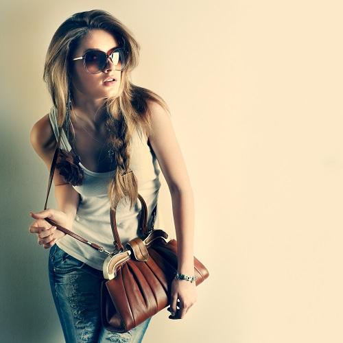 bolsa ideal, bolsa feminina, mulher de ólulos de sol com bolsa marrom
