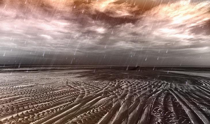 A foto mostra um cenário de chuva no deserto, fazendo referência às pragas no deserto