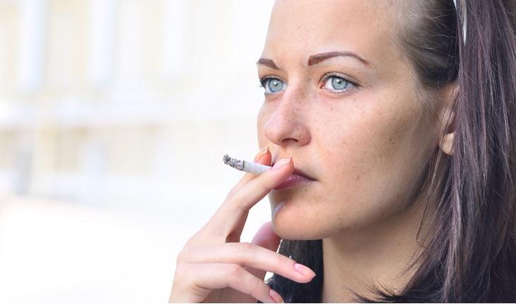 mulher de olhos claros fumando cigarro