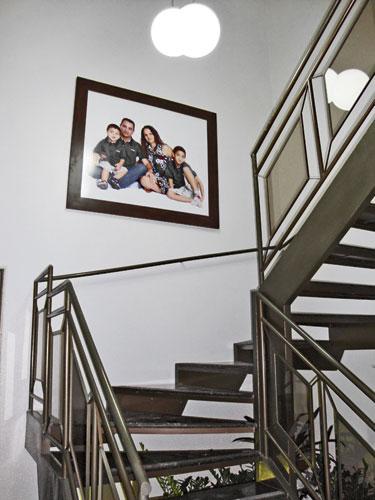 Parede com foto de família emoldurada e escadaria